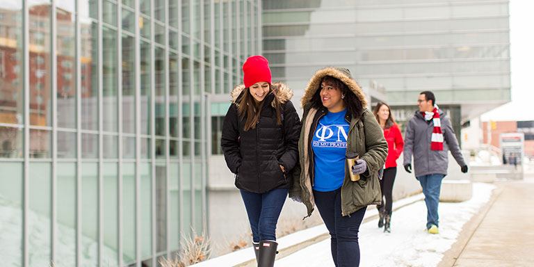 Students walk by the IUPUI Campus Center on a snowy day.